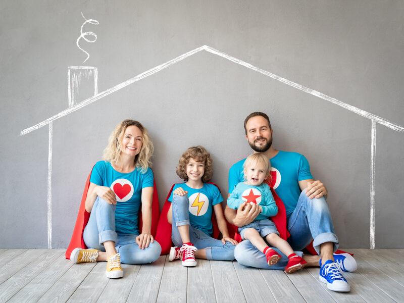 Family of superheroes playing at home. Father, mother, daughter and son having fun together. Parents with children pretend to be a super heroes